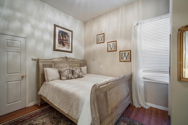 bedroom featuring dark wood-type flooring and baseboards