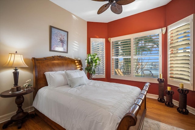 bedroom with ceiling fan, baseboards, and wood finished floors