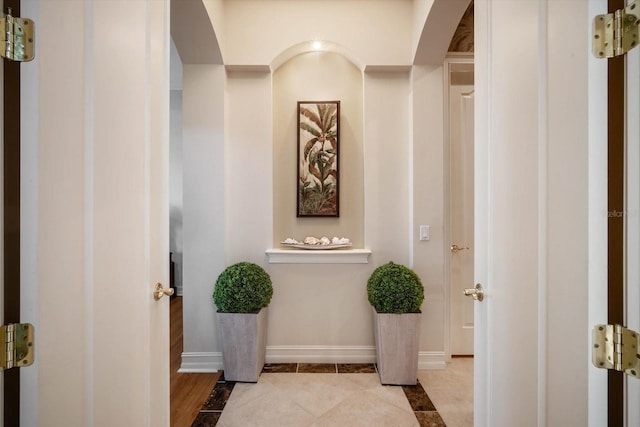 interior space featuring baseboards and light tile patterned flooring