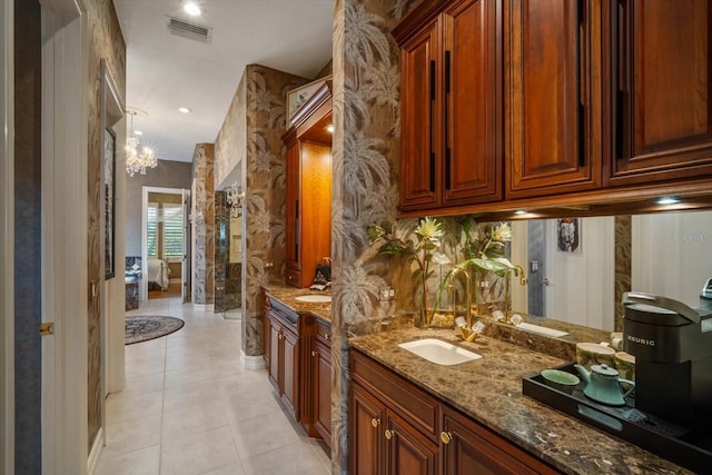 bathroom featuring wallpapered walls, visible vents, tile patterned floors, a sink, and two vanities