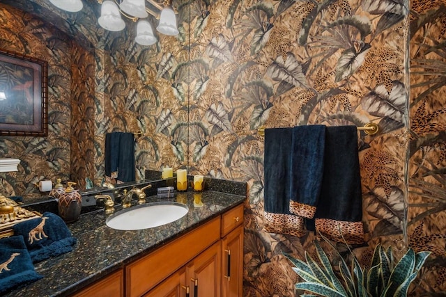 bathroom featuring vanity and wallpapered walls