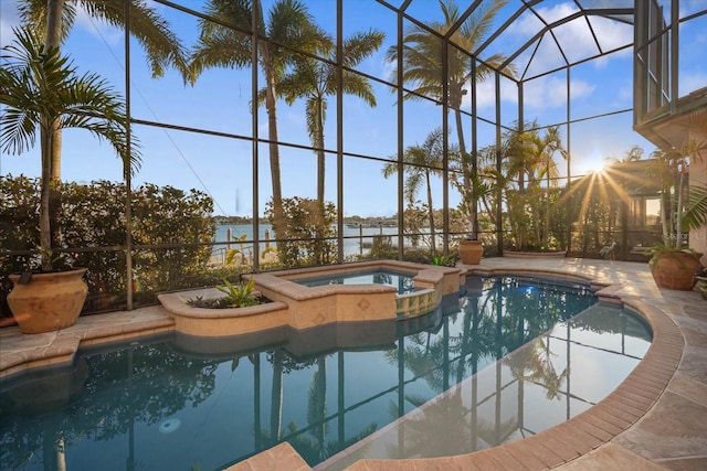 view of pool with a lanai, a water view, a pool with connected hot tub, and a patio