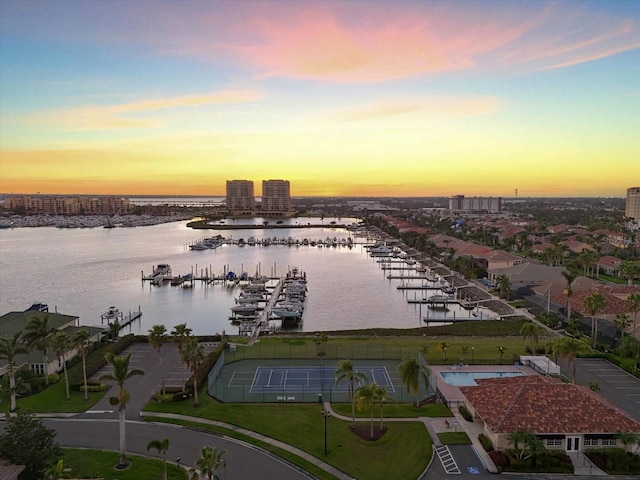 aerial view at dusk featuring a water view