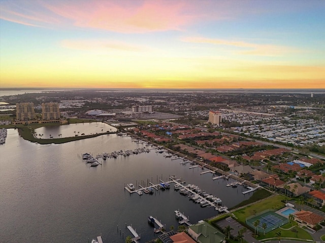 aerial view at dusk with a water view and a city view