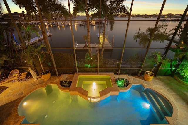 view of playground with a water view, a patio, and an in ground hot tub