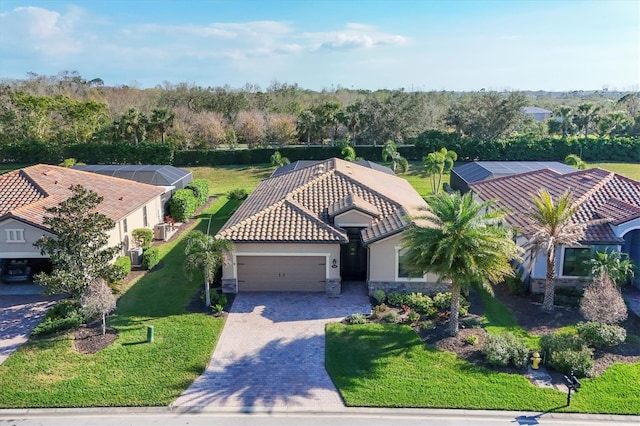 view of front of home with decorative driveway, a tile roof, an attached garage, and stucco siding