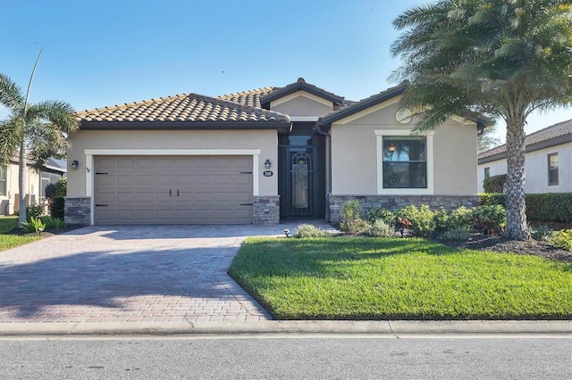 view of front of house featuring a garage, stone siding, decorative driveway, stucco siding, and a front lawn