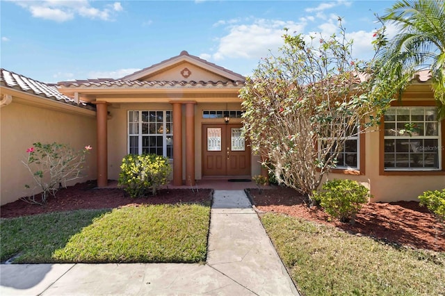 property entrance featuring french doors and a yard