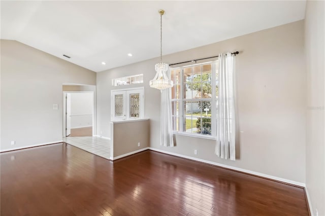 unfurnished dining area featuring lofted ceiling and wood-type flooring