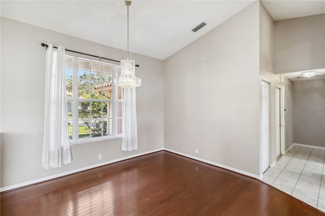 unfurnished dining area featuring an inviting chandelier and light hardwood / wood-style floors