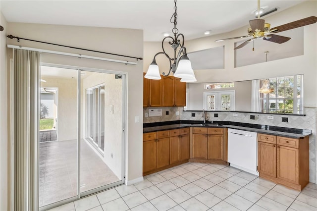 kitchen featuring white dishwasher, sink, pendant lighting, and vaulted ceiling