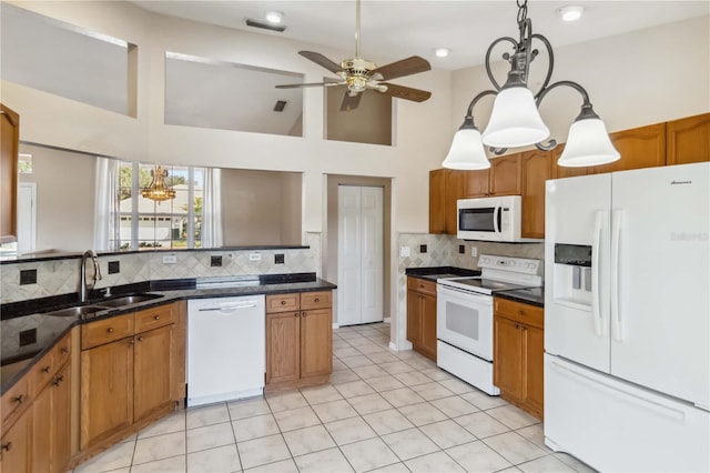 kitchen featuring decorative light fixtures, sink, decorative backsplash, light tile patterned floors, and white appliances