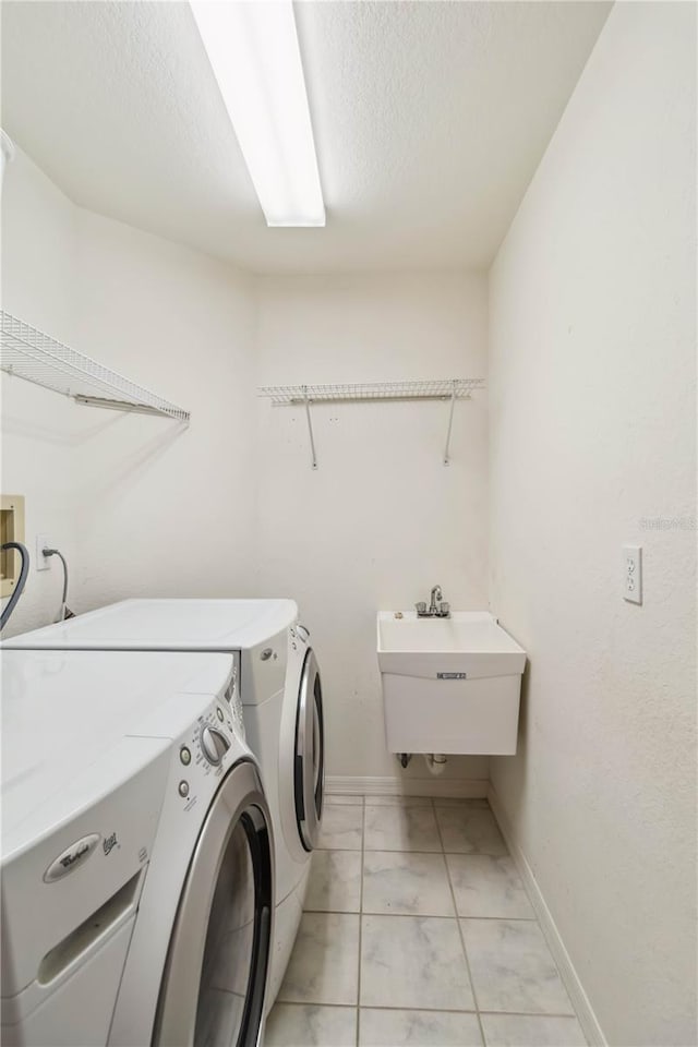 washroom with washer and clothes dryer, sink, and a textured ceiling