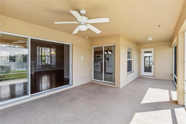 unfurnished sunroom with ceiling fan