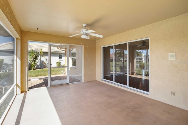 unfurnished sunroom featuring ceiling fan