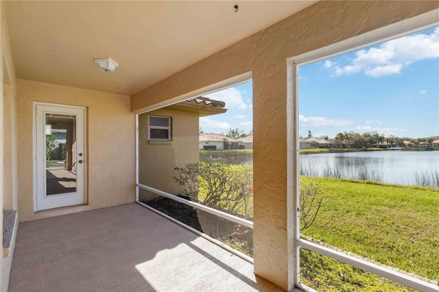 unfurnished sunroom featuring a water view