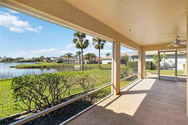 unfurnished sunroom featuring a water view and ceiling fan