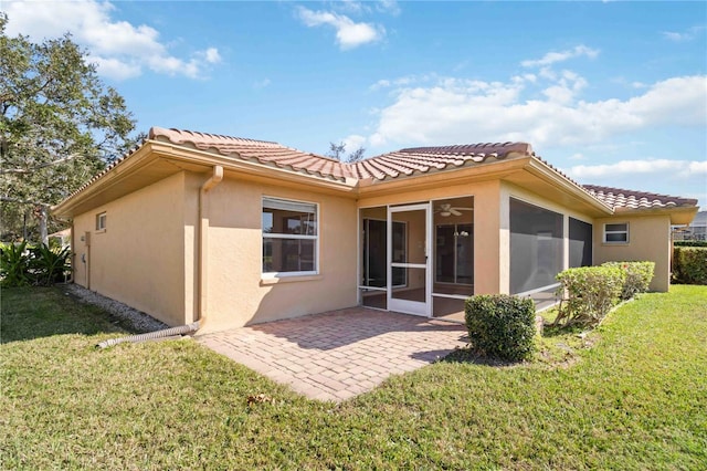 back of property with a patio area, a sunroom, and a lawn