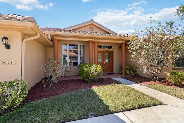 doorway to property featuring a lawn