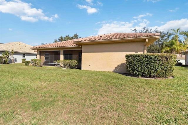 rear view of house with a sunroom and a yard