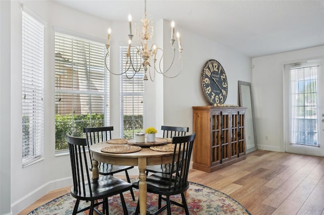 dining space featuring an inviting chandelier and light hardwood / wood-style floors