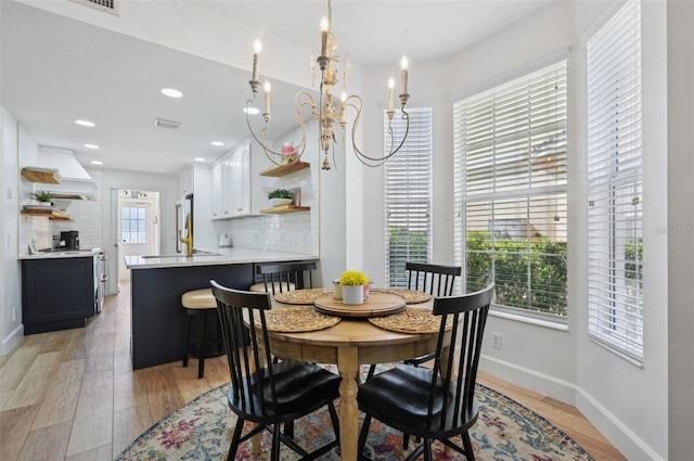 dining space with a chandelier and light wood-type flooring