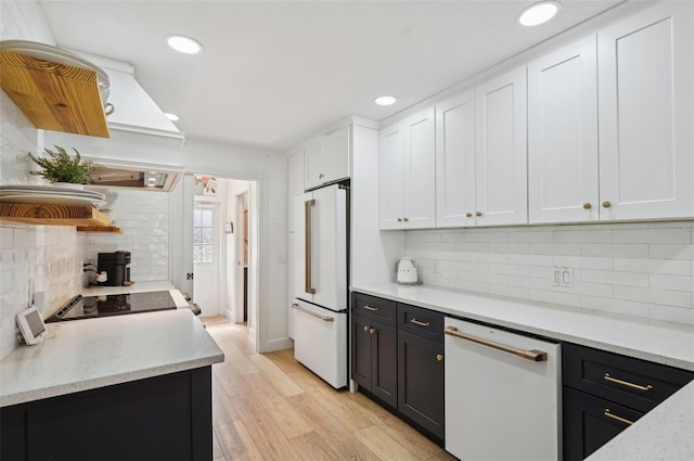 kitchen with light wood-type flooring, white cabinets, white appliances, and decorative backsplash