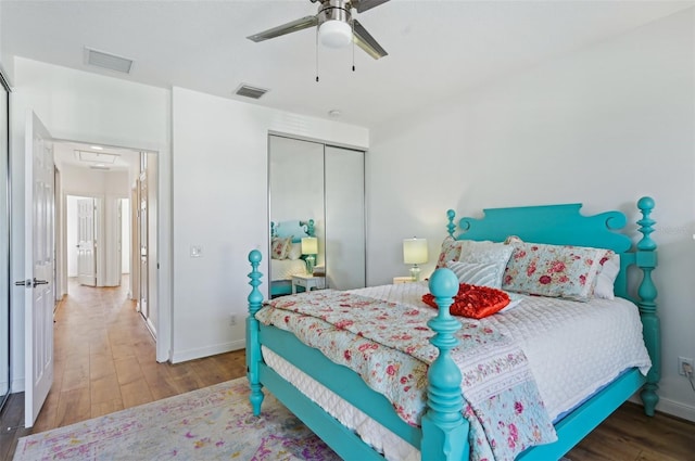 bedroom with hardwood / wood-style flooring, ceiling fan, and a closet