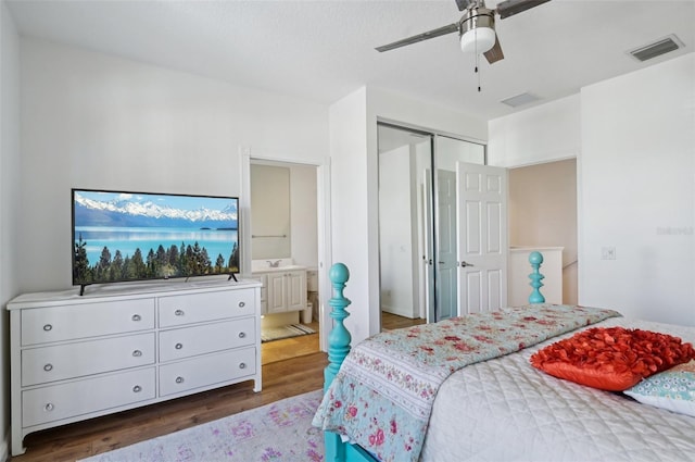 bedroom with dark hardwood / wood-style flooring, connected bathroom, a closet, and ceiling fan