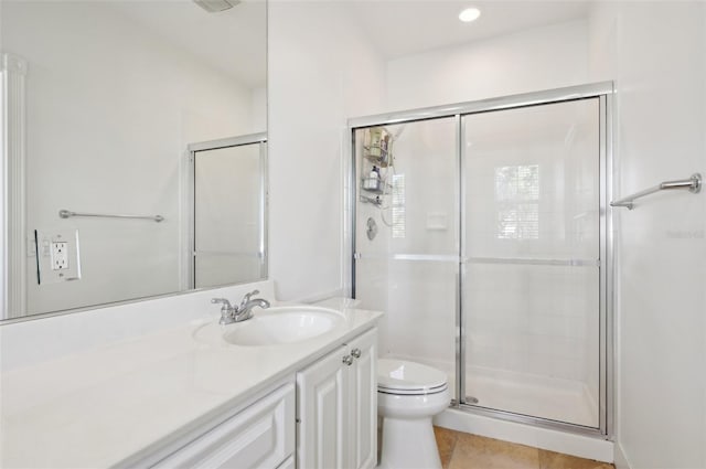 bathroom with tile patterned flooring, vanity, a shower with shower door, and toilet