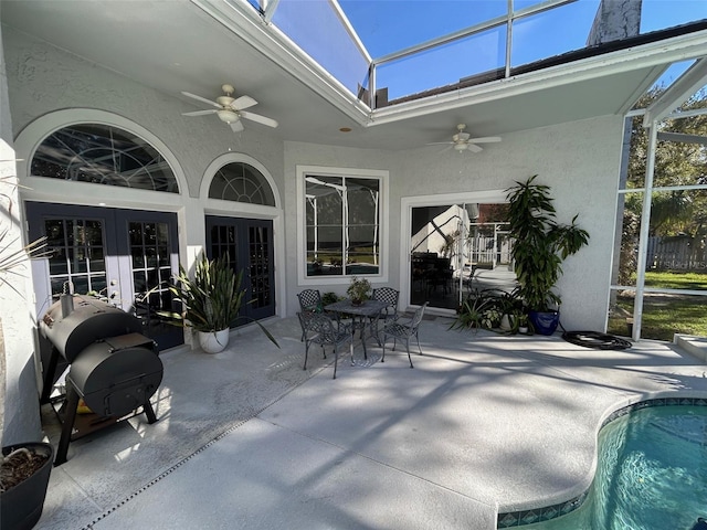 view of patio / terrace featuring a lanai, french doors, and ceiling fan