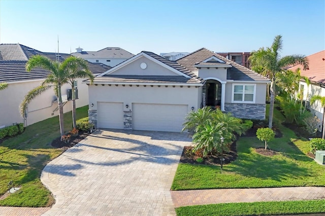 view of front facade featuring a front yard, an attached garage, stucco siding, stone siding, and decorative driveway