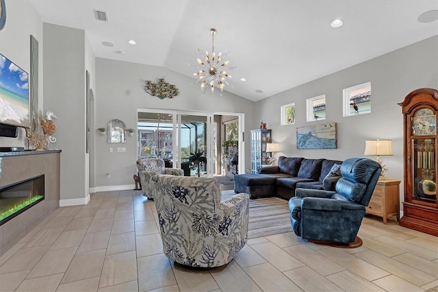 living area with a glass covered fireplace, an inviting chandelier, light tile patterned floors, baseboards, and vaulted ceiling