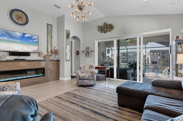 living room with visible vents, arched walkways, an inviting chandelier, a fireplace, and baseboards