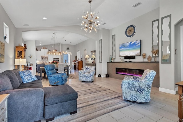 living room with visible vents, lofted ceiling, arched walkways, a glass covered fireplace, and a notable chandelier