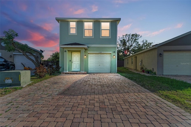 view of front of house with a garage, decorative driveway, and stucco siding