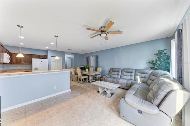 living area featuring recessed lighting, a ceiling fan, and baseboards