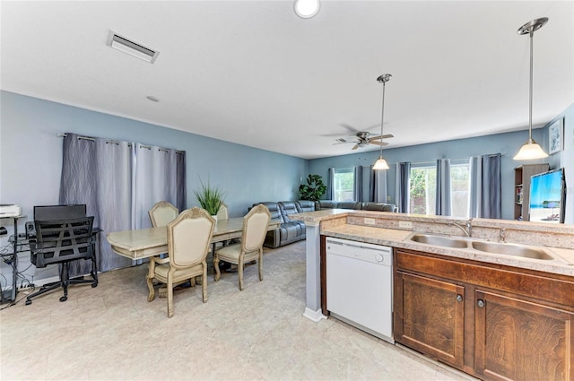 kitchen featuring visible vents, dishwasher, hanging light fixtures, light countertops, and a sink