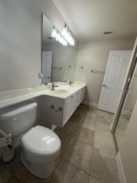 bathroom with tile patterned flooring, vanity, and toilet