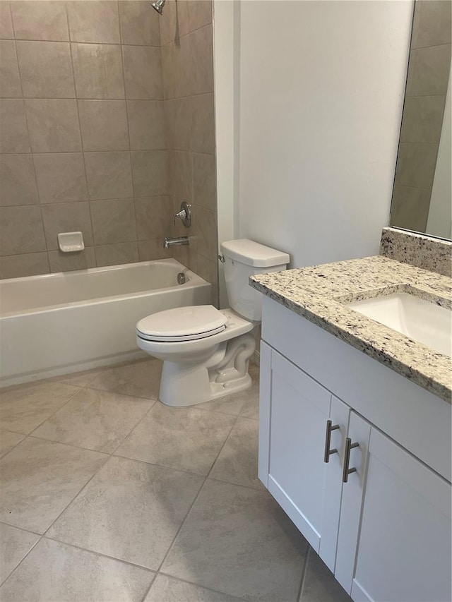 full bathroom featuring vanity, tile patterned flooring, toilet, and tiled shower / bath