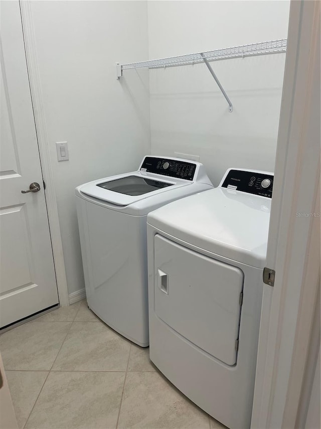 laundry area with light tile patterned flooring and independent washer and dryer