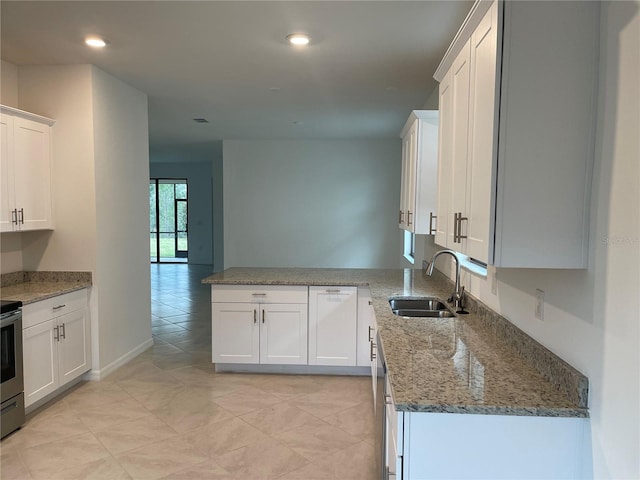 kitchen with sink, light stone counters, kitchen peninsula, stainless steel electric stove, and white cabinets