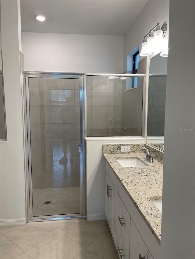 bathroom with vanity, a shower with shower door, and tile patterned flooring