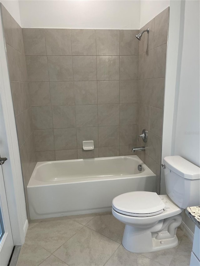 bathroom featuring tiled shower / bath, tile patterned floors, and toilet