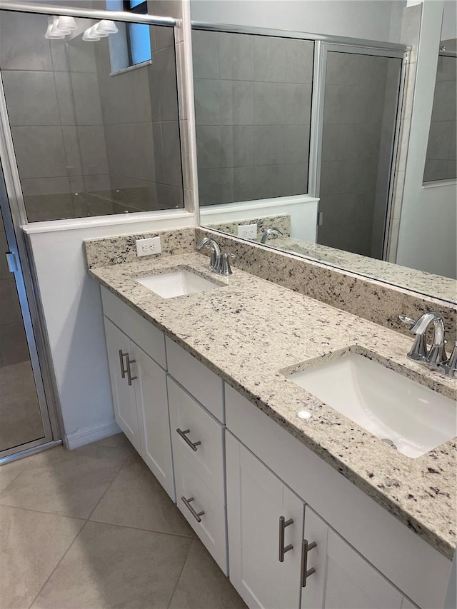 bathroom with tile patterned flooring, vanity, and walk in shower