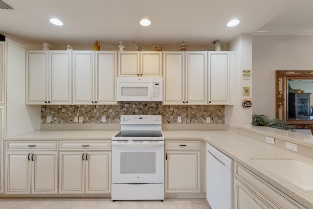 kitchen with light tile patterned flooring, sink, backsplash, and white appliances