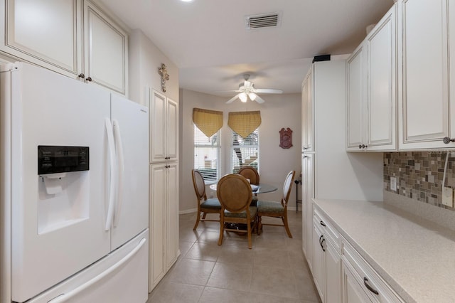 kitchen featuring light tile patterned floors, ceiling fan, white cabinetry, tasteful backsplash, and white fridge with ice dispenser