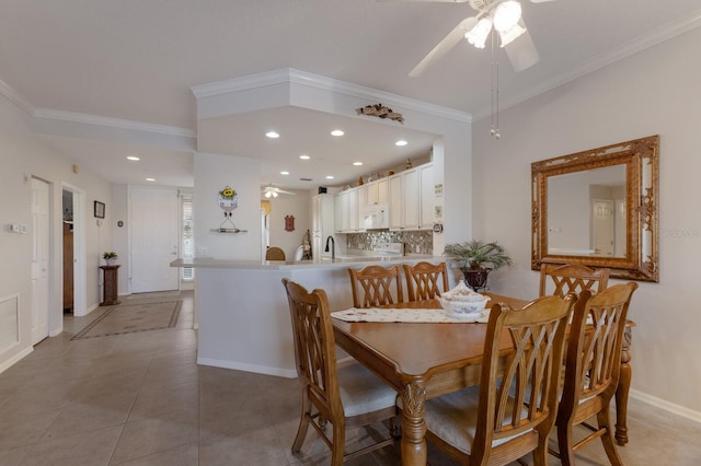 tiled dining area featuring ornamental molding and ceiling fan