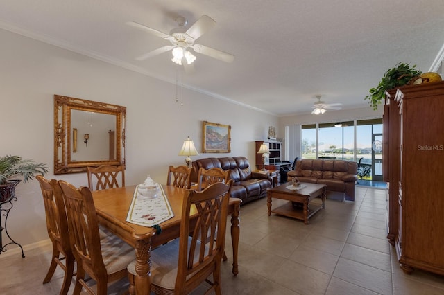 tiled dining area featuring ceiling fan, ornamental molding, and a textured ceiling