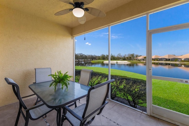 unfurnished sunroom featuring a water view and ceiling fan